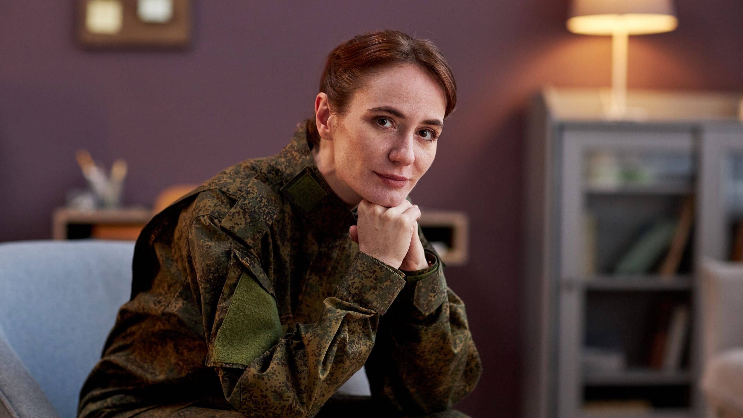 GettyImages-1470572975 Soldier resting chin on hands, thoughtful expression.