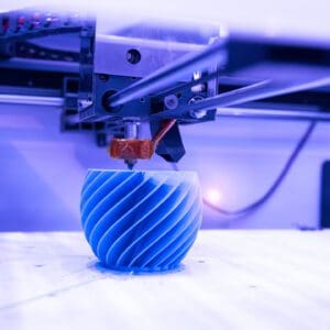 3D printer creating a blue spiral vase.